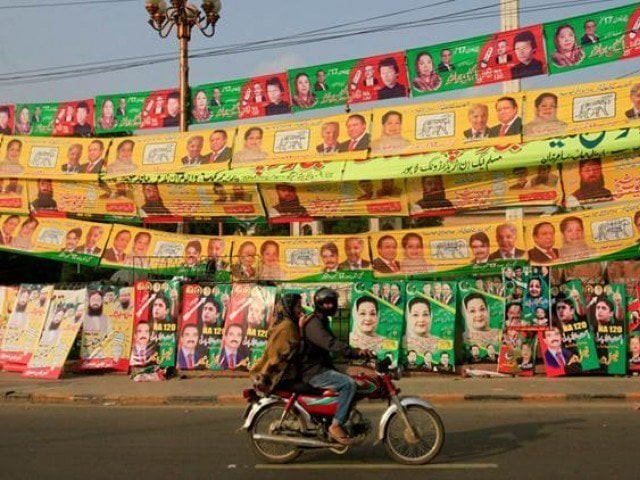 residents ride on bike past election campaign signs along a road in lahore photo reuters residents ride on bike past election campaign signs along a road in lahore photo reuters