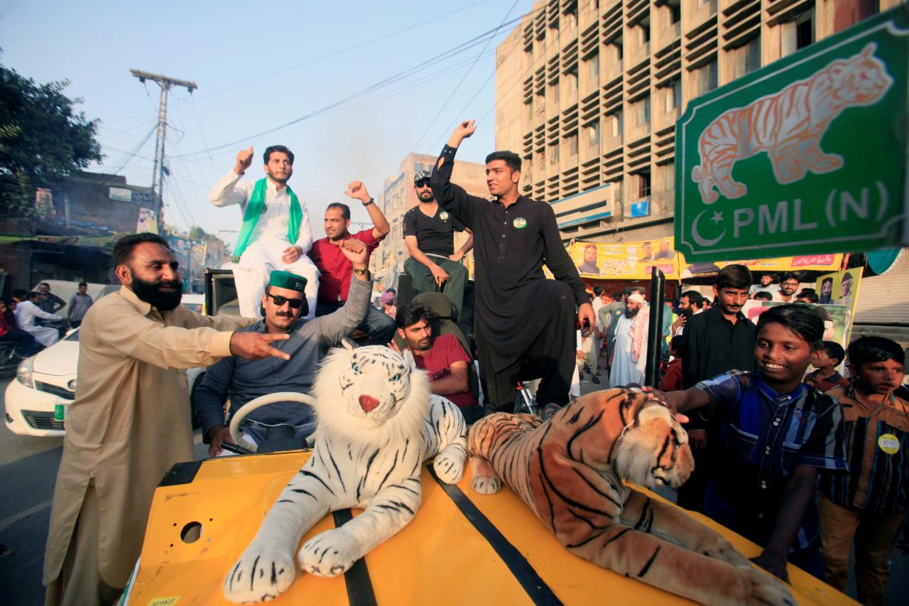 supporters of the pmln political party cheer on their candidate outside a polling station in lahore pakistan photo reuters