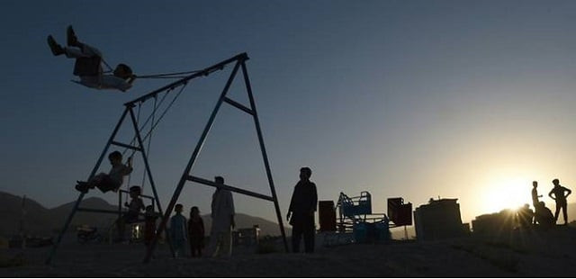afghan children play on a swing on the outskirts of kabul explosives planted or discarded in the city take a deadly toll on the young photo afp