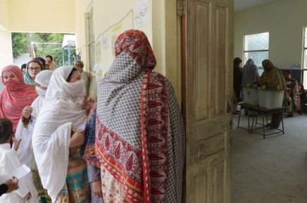 a woman r casts her vote as others wait in a queue l at a polling station in islamabad photo afp