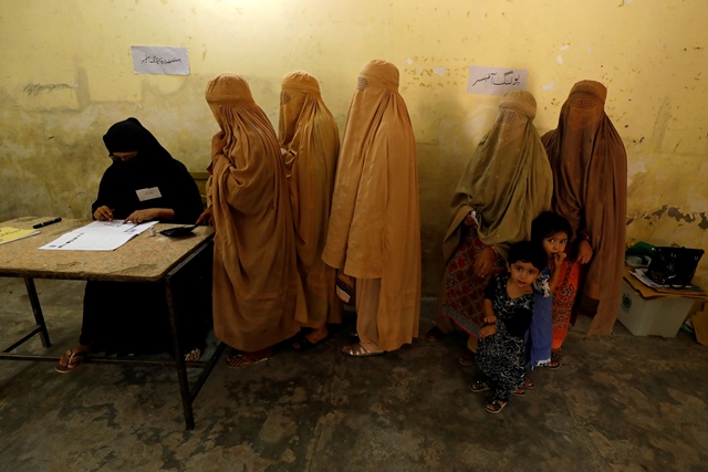 women clad in burqas stand in line to cast their ballot at a polling station during general election in peshawar photo reuters