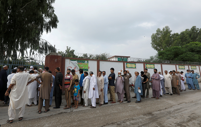 people stand in a line as they wait for a polling station to open during general election in rawalpindi photo reuters
