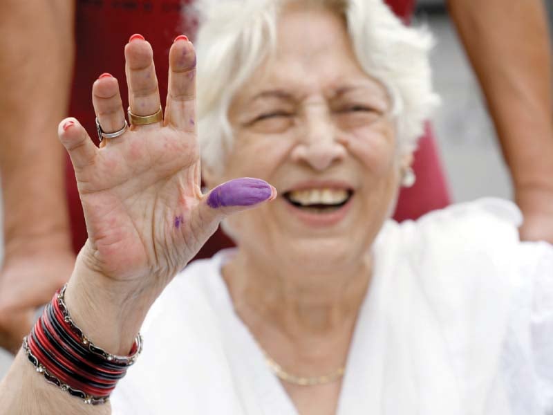 an elderly woman shows off her inked thumb after casting her vote in karachi photo reuters