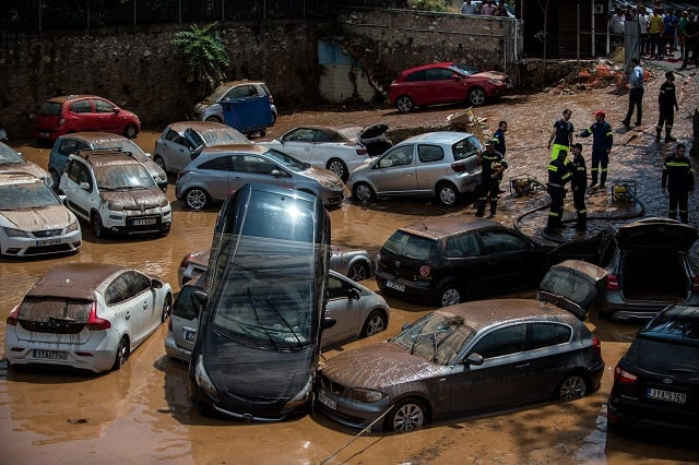 this general view shows emergency workers among damaged vehicles in a open parking area of northern athens on july 26 2018 after a flash flood struck the greek capital photo afp this general view shows emergency workers among damaged vehicles in a open parking area of northern athens on july 26 2018 after a flash flood struck the greek capital photo afp