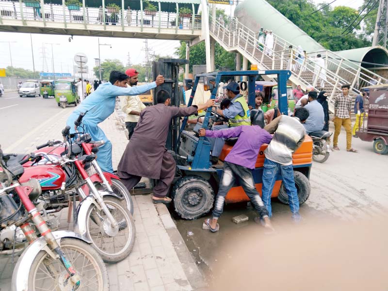 citizens try to start a faulty lifter outside lahore children s hospital photo imran adnan