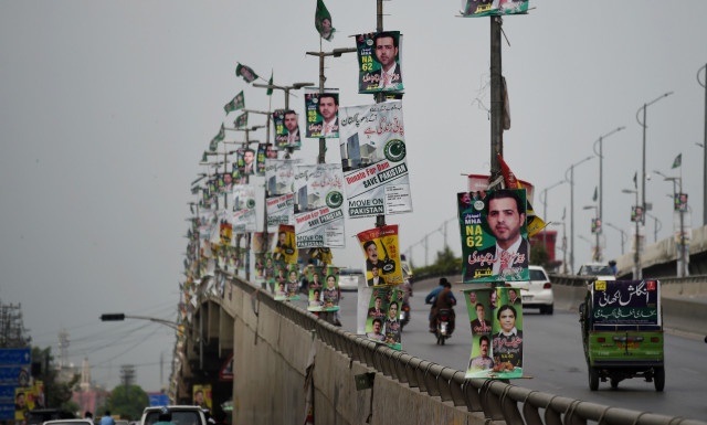 commuters drive along a flyover bridge decorated with posters of election candidates in rawalpindi july 22 2018 photo afp commuters drive along a flyover bridge decorated with posters of election candidates in rawalpindi july 22 2018 photo afp