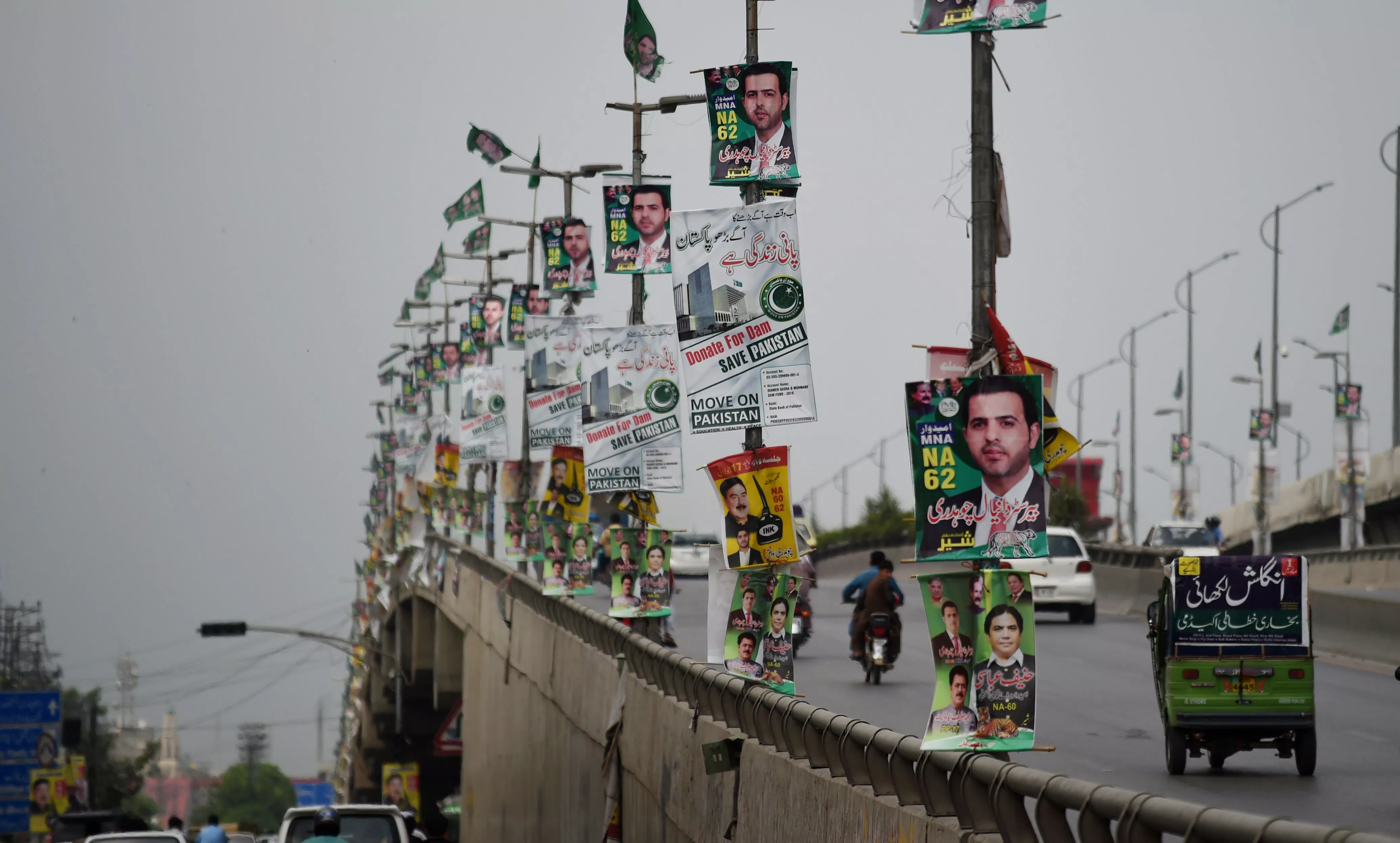 commuters drive along a flyover bridge decorated with posters of election candidates in rawalpindi july 22 2018 photo afp commuters drive along a flyover bridge decorated with posters of election candidates in rawalpindi july 22 2018 photo afp