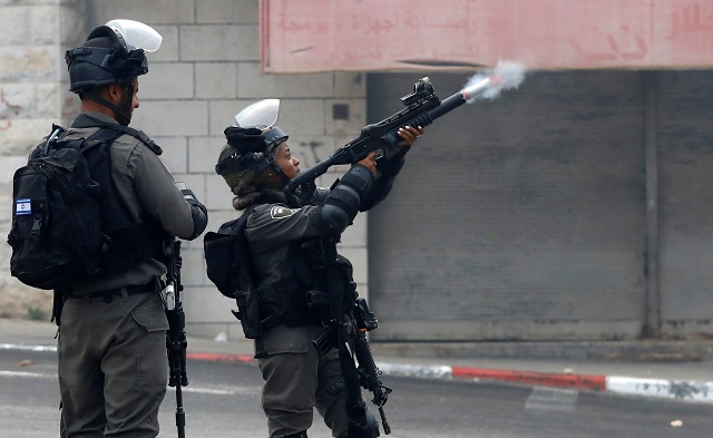 an israeli border policewoman fires a tear gas canister towards palestinians during clashes in the village of khobar near ramallah in the occupied west bank july 27 2018 photo reuters