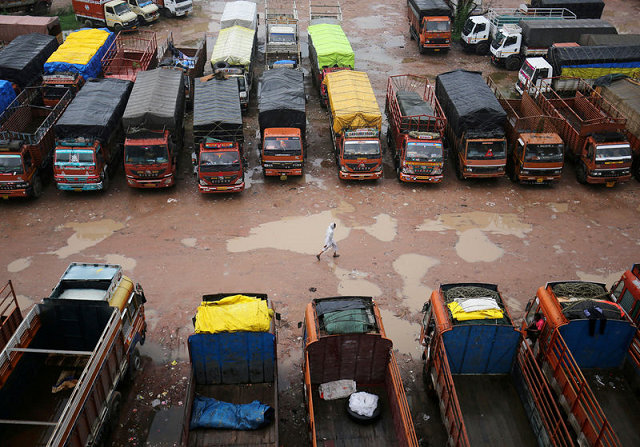a driver walks past parked trucks inside a depot during a nationwide strike in ahmedabad india july 20 2018 photo reuters a driver walks past parked trucks inside a depot during a nationwide strike in ahmedabad india july 20 2018 photo reuters