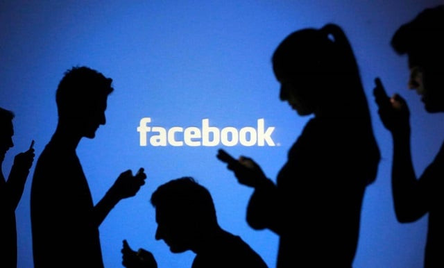 people are silhouetted as they pose with laptops in front of a screen projected with a facebook logo in this picture illustration taken in zenica october 29 2014 photo reuters