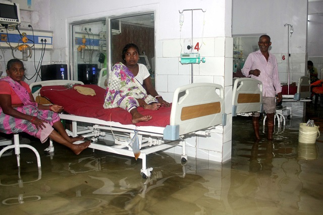 this photograph taken in july 29 shows a patient and relatives in a waterlogged room at nalanda medical college and hospital nmch following heavy monsoon rain photo afp