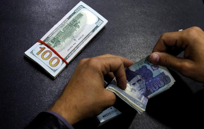 a currency trader counts pakistani rupee notes photo reuters