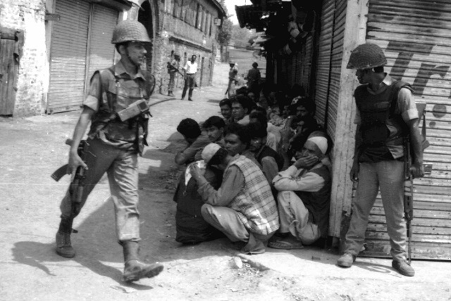 this photograph taken in 1993 shows indian border security forces bsf gathering kashmiri men to check identification during a raid on suspected militants in srinagar photo afp
