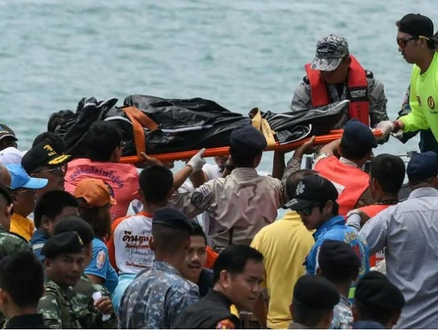 thai rescue personnel carry a body bag bearing the recovered body of a passenger at chalong pier in phuket photo afp