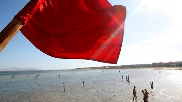 a red flag serving as a warning of shark sightings flutters over tourists in the red sea resort of sharm el sheikh on dec 8 2010 photo afp a red flag serving as a warning of shark sightings flutters over tourists in the red sea resort of sharm el sheikh on dec 8 2010 photo afp