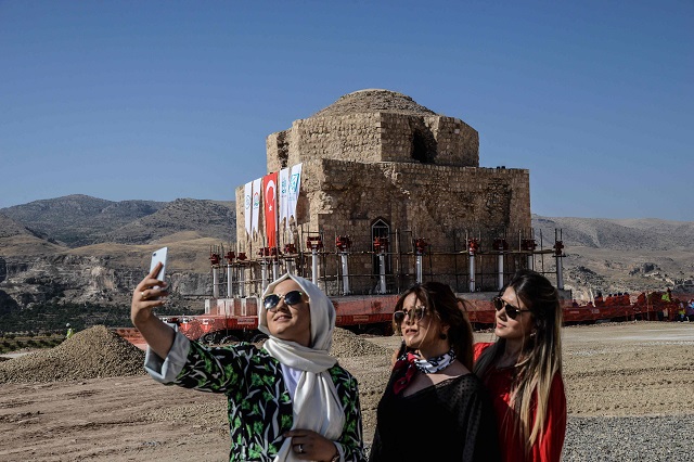 women take a selfie picture with their mobile phone as the artuklu hamam is loaded onto a wheeled platform an moved down a specially constructed road on august 6 2018 photo afp