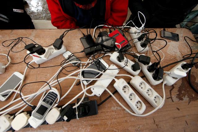 migrants charge their mobile phones with a generator at the calais refugee camp northern france january 11 2016 photo reuters