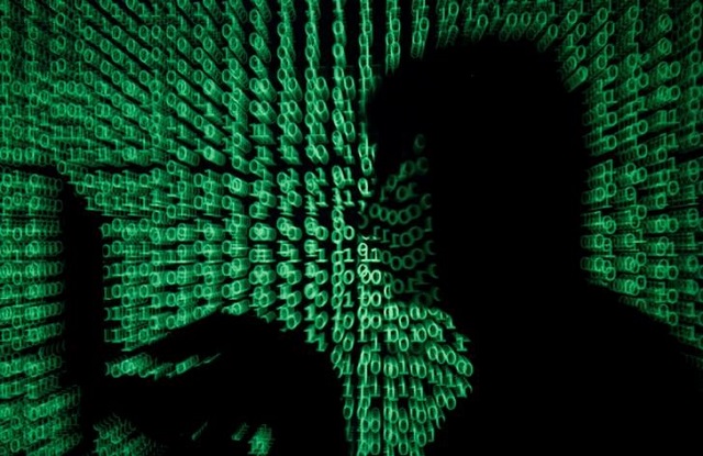 a man holds a laptop computer as cyber code is projected on him in this illustration picture taken on may 13 2017 photo reuters