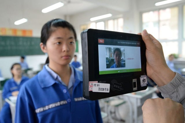 a teacher uses a machine which employs both fingerprint and facial recognition technology to check the identification of a student before a simulated college entrance exam in handan in china 039 s northern hebei province on june 6 2017 photo afp a teacher uses a machine which employs both fingerprint and facial recognition technology to check the identification of a student before a simulated college entrance exam in handan in china 039 s northern hebei province on june 6 2017 photo afp