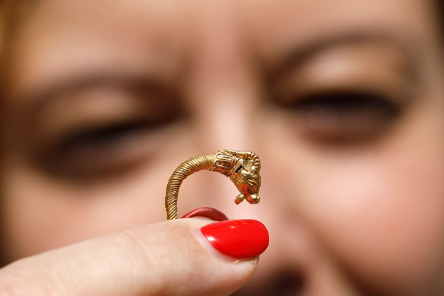 an israeli archaeologist shows a rare golden earring believed to be more than 2 000 years old discovered at the archeological site of the city of david in east jerusalem near the walls of the old city on 8 august 2018 photo afp