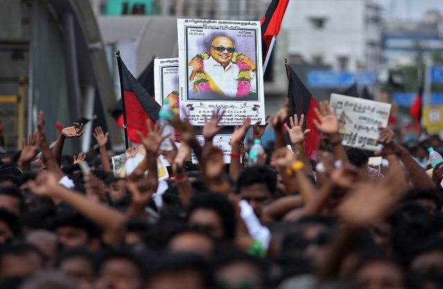 supporters hold the portrait of the indian tamil leader muthuvel karunanidhi during his funeral in chennai on august 8 2018 photo afp