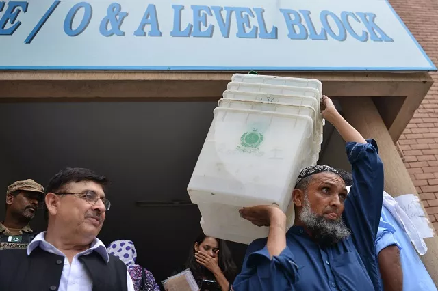 a pakistani election official carries ballot boxes at a distribution centre in islamabad on july 24 photo afp a pakistani election official carries ballot boxes at a distribution centre in islamabad on july 24 photo afp