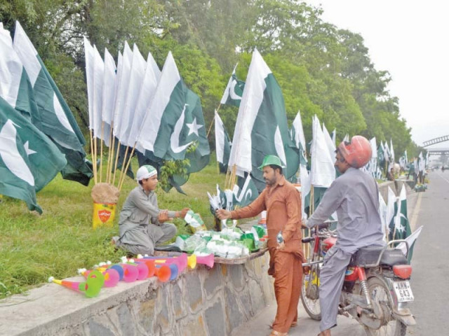 people selling flags and badges on green belt along islamabad expressway photo waseem nazir express people selling flags and badges on green belt along islamabad expressway photo waseem nazir express