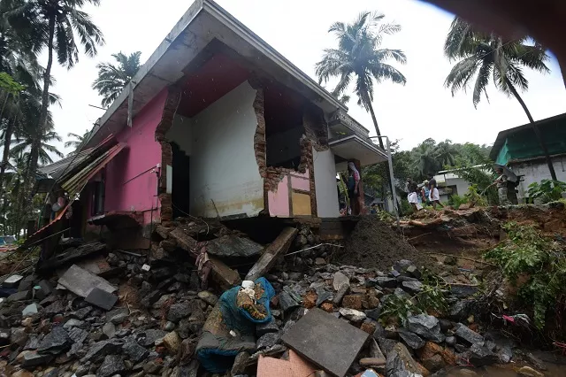 local residents look at a partially destroyed house after heavy monsoon rains led to a landslide in kannappankund in the indian state of kerala on august 11 2018 photo afp local residents look at a partially destroyed house after heavy monsoon rains led to a landslide in kannappankund in the indian state of kerala on august 11 2018 photo afp