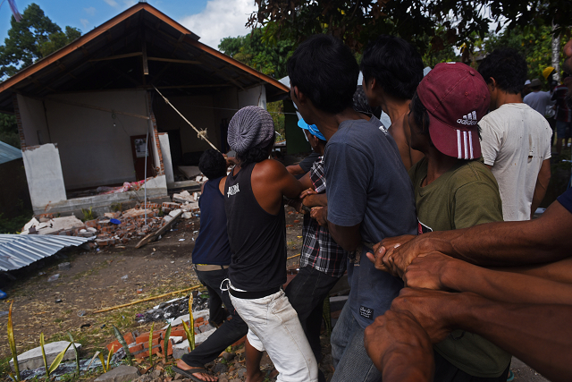 residents pull down an earthquake damaged house in kayangan north lombok indonesia photo reuters residents pull down an earthquake damaged house in kayangan north lombok indonesia photo reuters