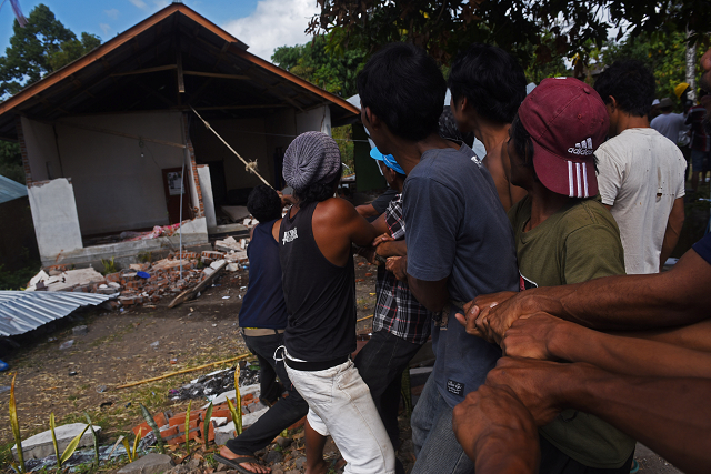 residents pull down an earthquake damaged house in kayangan north lombok indonesia photo reuters