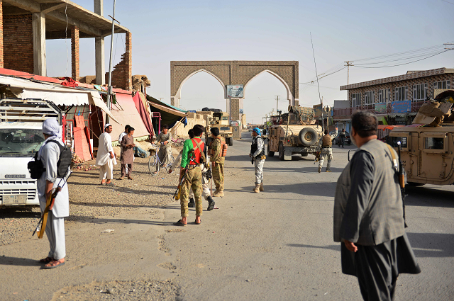 afghan security forces and afghan militia stand along a road during clashes between taliban militants and afghan security forces in ghazni province photo afp