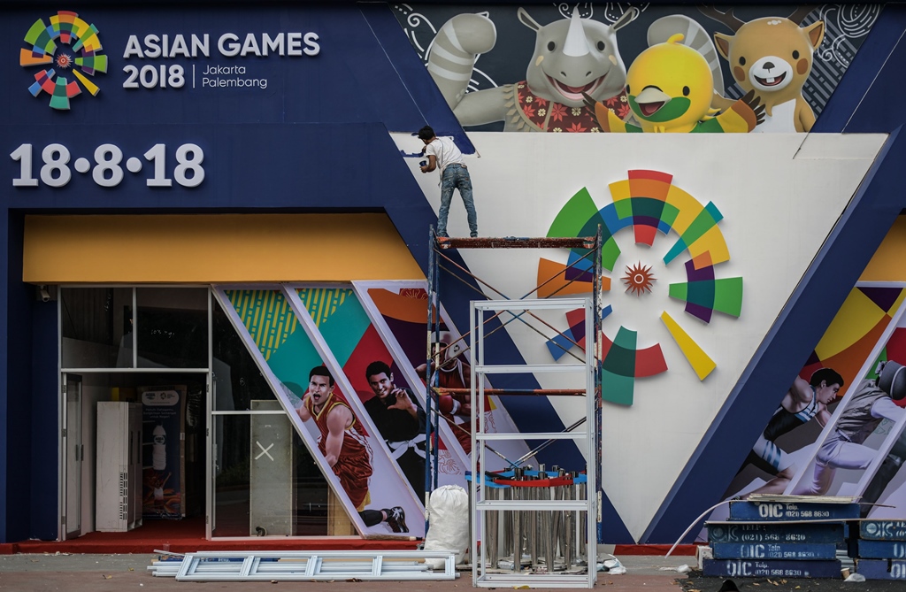 preparations underway a worker paints an installation showing mascots kaka l bhin bhin c and atung r ahead of the 2018 asian games in jakarta on august 14 photo afp