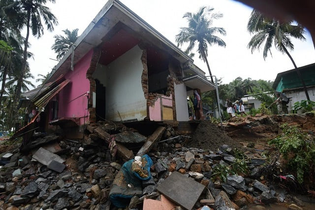 local residents look at a partially destroyed house after heavy monsoon rains led to a landslide in kannappankund in the indian state of kerala on august 11 2018 photo afp local residents look at a partially destroyed house after heavy monsoon rains led to a landslide in kannappankund in the indian state of kerala on august 11 2018 photo afp