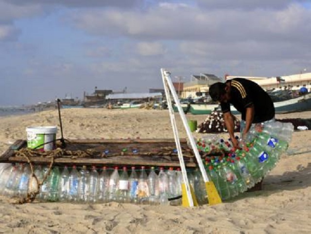 palestinian fisherman mu ath abu zeid repairs his boat that he made of 700 plastic empty bottles on a beach in rafah in the southern gaza strip photo afp