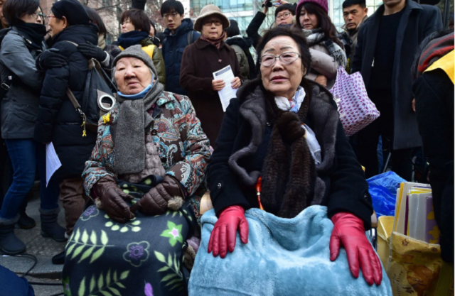 former comfort women gil won ok left and lee yong soo who were forced into wartime sexual slavery for japanese soldiers sit during an anti japanese rally in seoul photo afp file