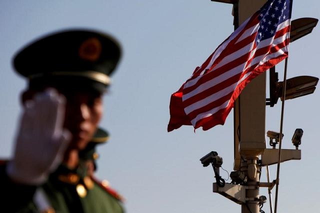 a paramilitary policeman gestures under a pole with security cameras us and china 039 s flags near the forbidden city ahead of the visit by us president donald trump to beijing china november 8 2017 photo reuters