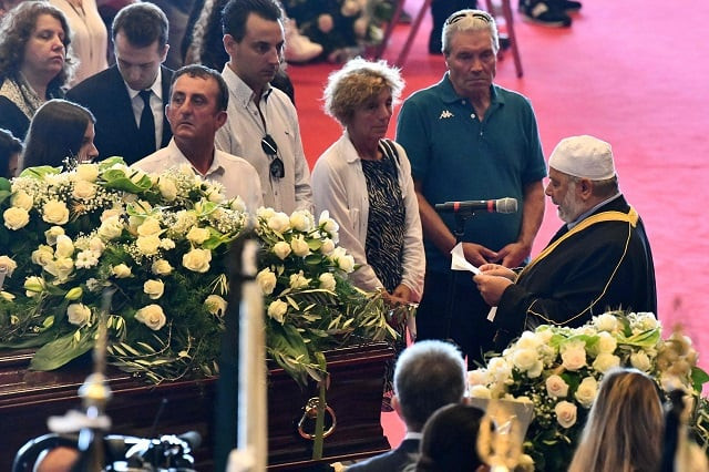 a muslim imam r reads a prayer in front of coffins during the mass for the state funeral of the victims of the morandi bridge collapse in genoa on august 18 2018 photo afp a muslim imam r reads a prayer in front of coffins during the mass for the state funeral of the victims of the morandi bridge collapse in genoa on august 18 2018 photo afp