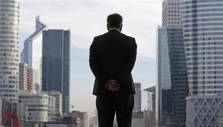 a businessman is silhouetted as he stands under the arche de la defense in the financial district west of paris photo reuters