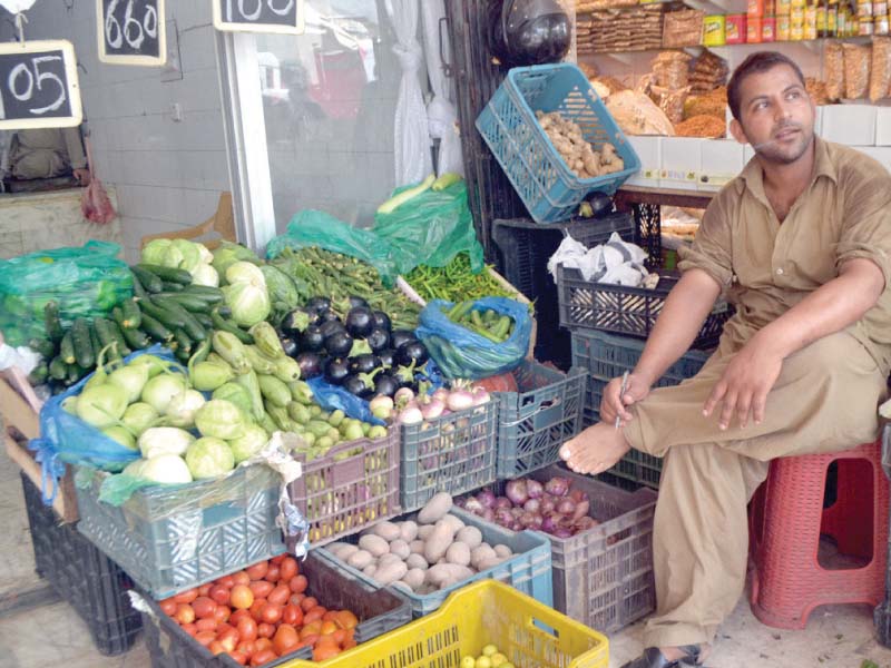 a vegetable vendor sits at his stall photo waseem naizr express