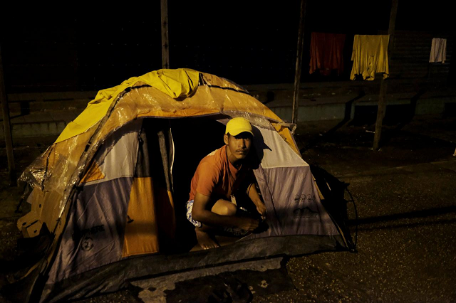 venezuelan man is pictured at the entrance of his tent set up along the street as he waits to show his passport or identity card next day at the pacaraima border control roraima state brazil august 8 2018 picture taken august 8 2018 photo reuters
