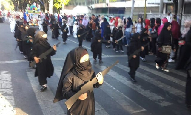 young girls wore niqab style black veils and carried cardboard cutouts of guns in the parade photo twitter young girls wore niqab style black veils and carried cardboard cutouts of guns in the parade photo twitter
