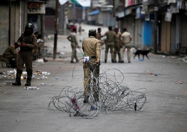an indian policeman pulls concertina wire to lay a barricade on a road during a curfew in srinagar july 12 2016 photo reuters file