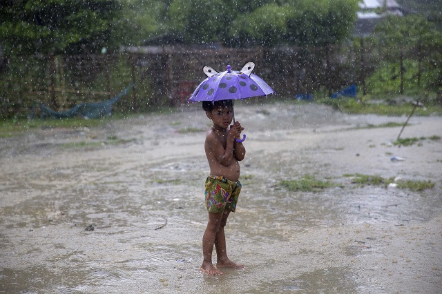 a rohingya muslim child holding an umbrella while under the rain at shwe zar village is seen during a government organized visit for journalists in maungdaw township rakhine state on august 23 2018 photo afp