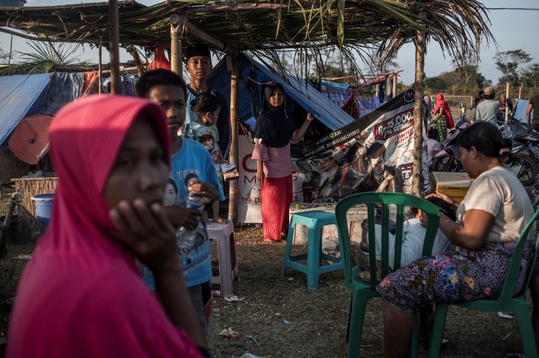 people look on at a temporary shelter in the village of menangga baris on indonesia 039 s lombok island on august 22 2018 after a series of recent earthquakes indonesian aid agencies and officials rushed on august 21 to help survivors after the third quake disaster in less than a month on lombok island where some 500 people have died and hundreds of thousands are homeless photo afp