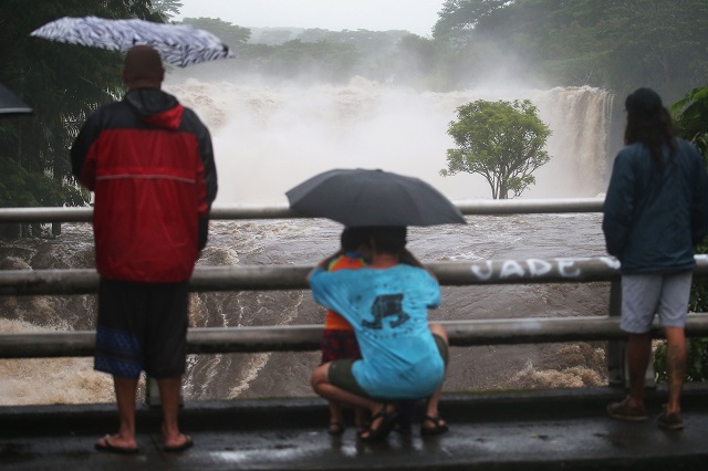 august 23 people gather on a bridge to watch the wailuku river flood waters on the big island on august 23 2018 in hilo hawaii photo afp