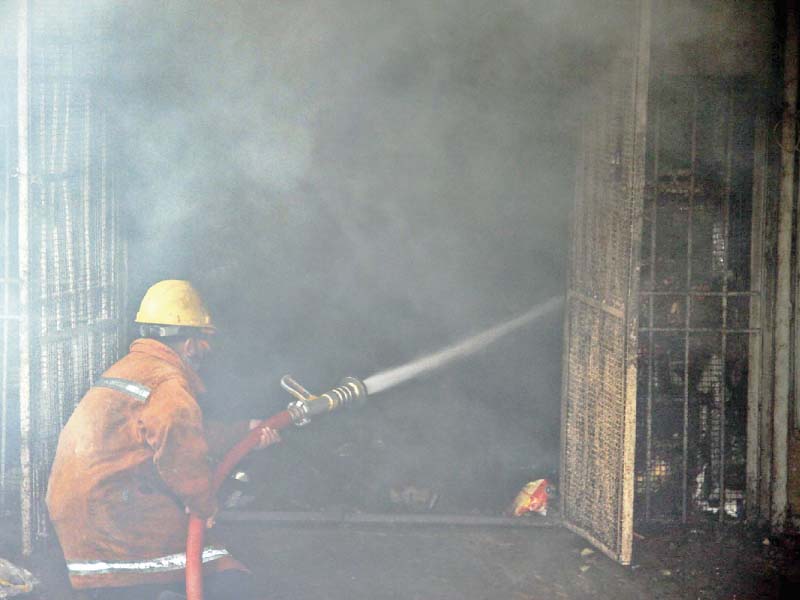 a firefighter extinguishes the blaze at a warehouse on sharae faisal photo ppi