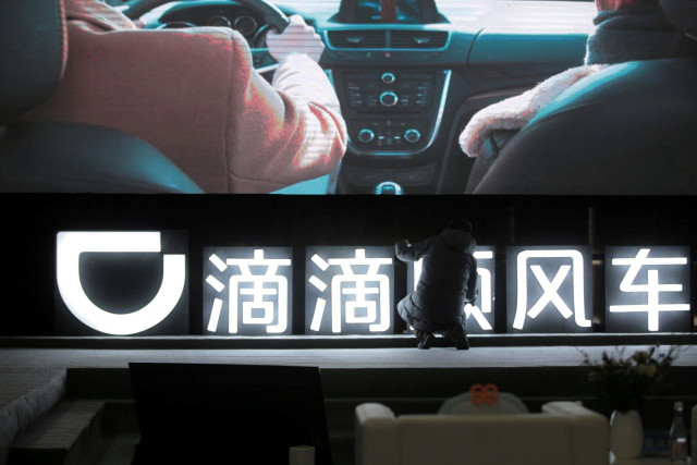 a man is seen in front of a didi sign before a promotional event of its hitch service for the spring festival travel rush photo reuters