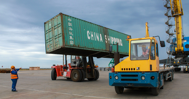 workers load a shipping crate in the kazakhstan 039 s caspian seaport of aktau on august 14 2018   with the outlines of its six idle cranes obscured by thick fog and pouring rain kazakhstan 039 s caspian seaport aktau seems an unlikely frontier on china 039 s much hyped new silk road but the sleepy port which has been badly hit in recent years by new oil routes is vying for a slice of the pie as competition for chinese trade warms up on the shores of the world 039 s largest inland sea photo afp