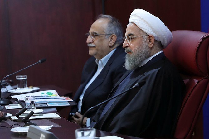 a handout picture provided by the office of iranian president hassan rouhani show him r sitting next to minister of economy masoud karbasian during a meeting with members of the ministry photo afp