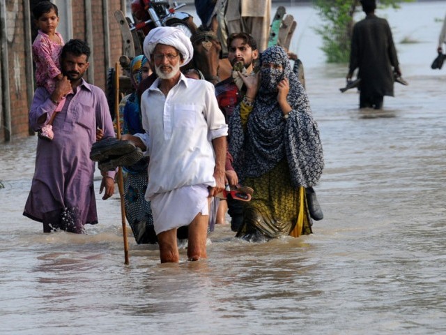 in this file photo flood affected villagers walk through water in murredke photo afp